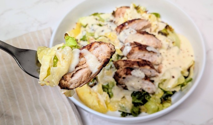 a bite of cabbage alfredo with chicken on it