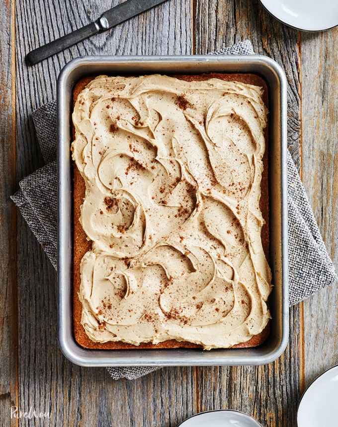 fun things to bake: aerial of cinnamon sheet cake with cider frosting on a wooden table