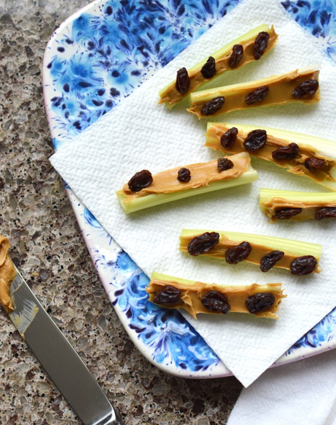 easy snacks to make at home: ants on a log made with celery, peanut butter and raisins